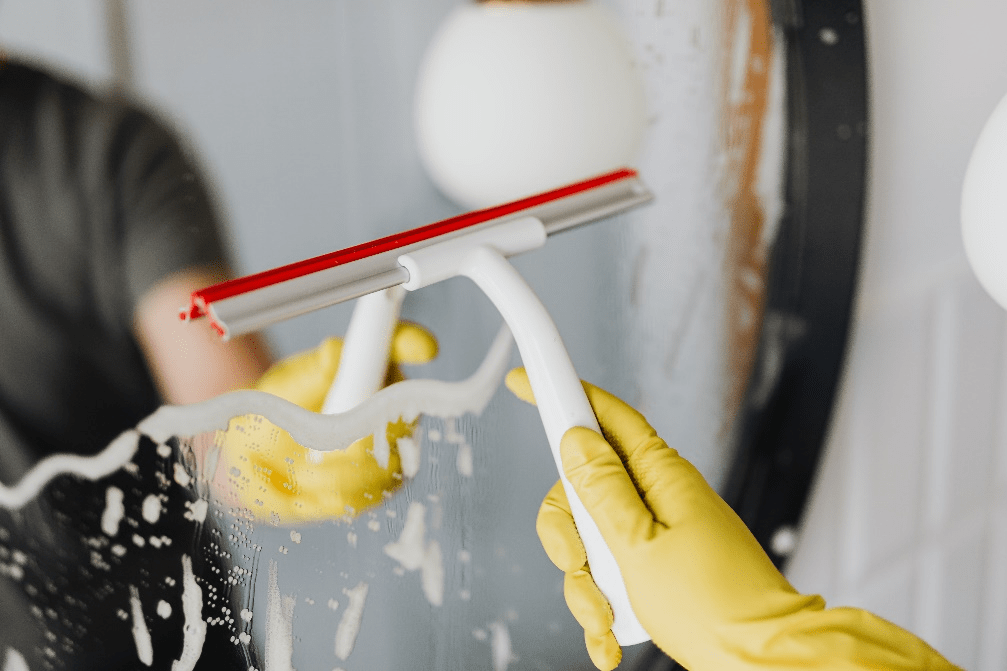Cleaning a mirror with a squeegee