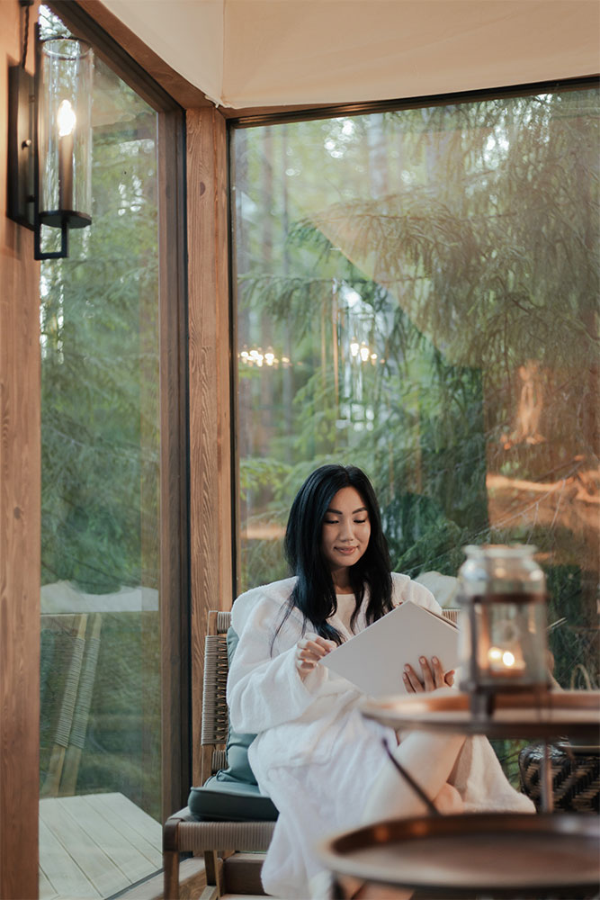  A woman reading in a room with glass windows