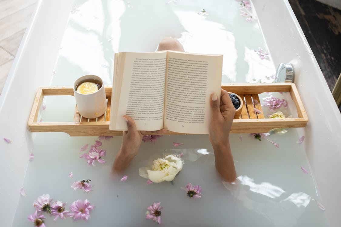 A woman reading a book in a bathtub